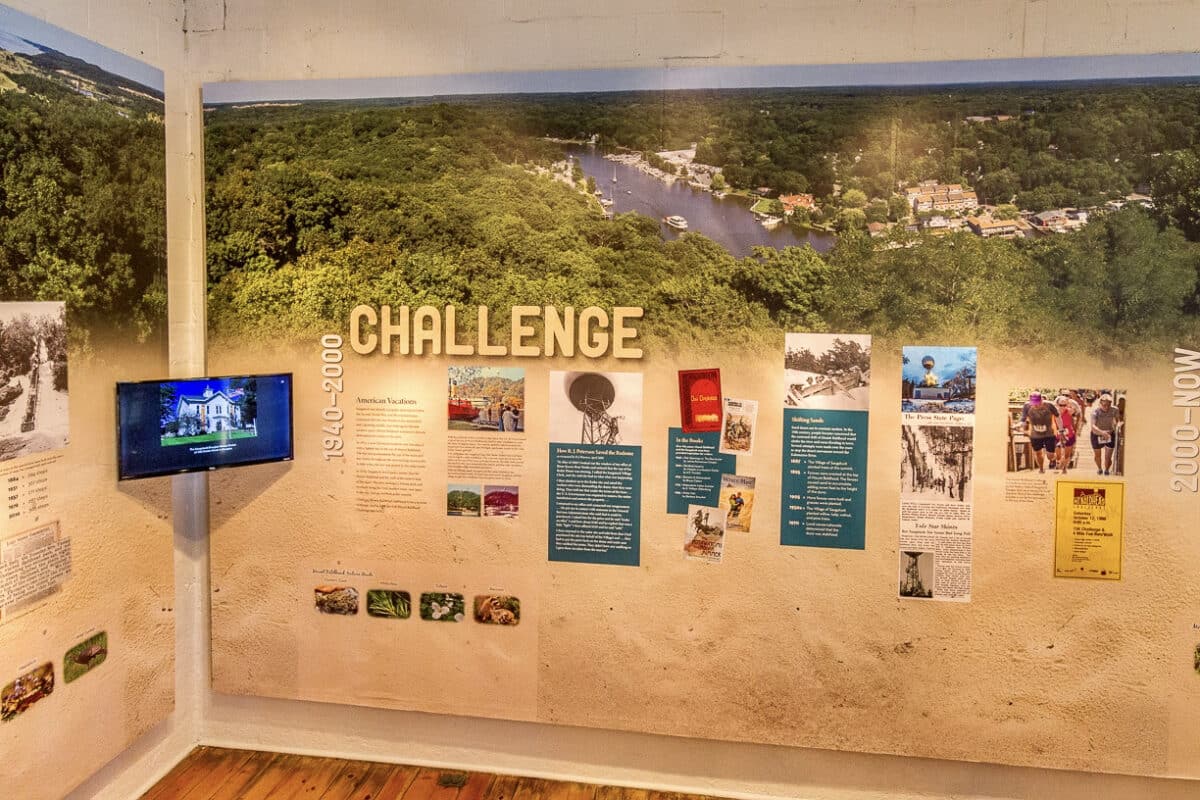 Wall of images labeled Challenge at the Lure of Mount Baldhead exhibit