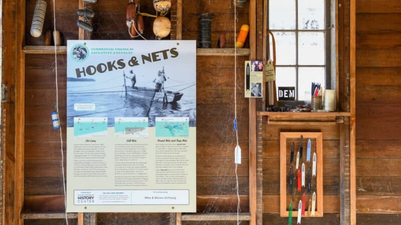 A view inside the shanty, showing fishing equipment and an interpretive poster
